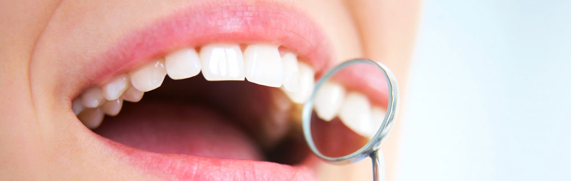 closeup of teeth with small mirror held up