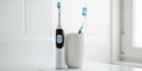 an electric and manual toothbrush next to each other