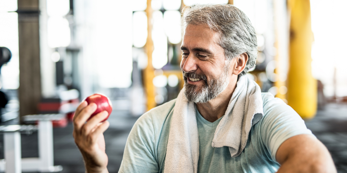 man eating an apple with confidence after replacing missing teeth with implants in nottingham